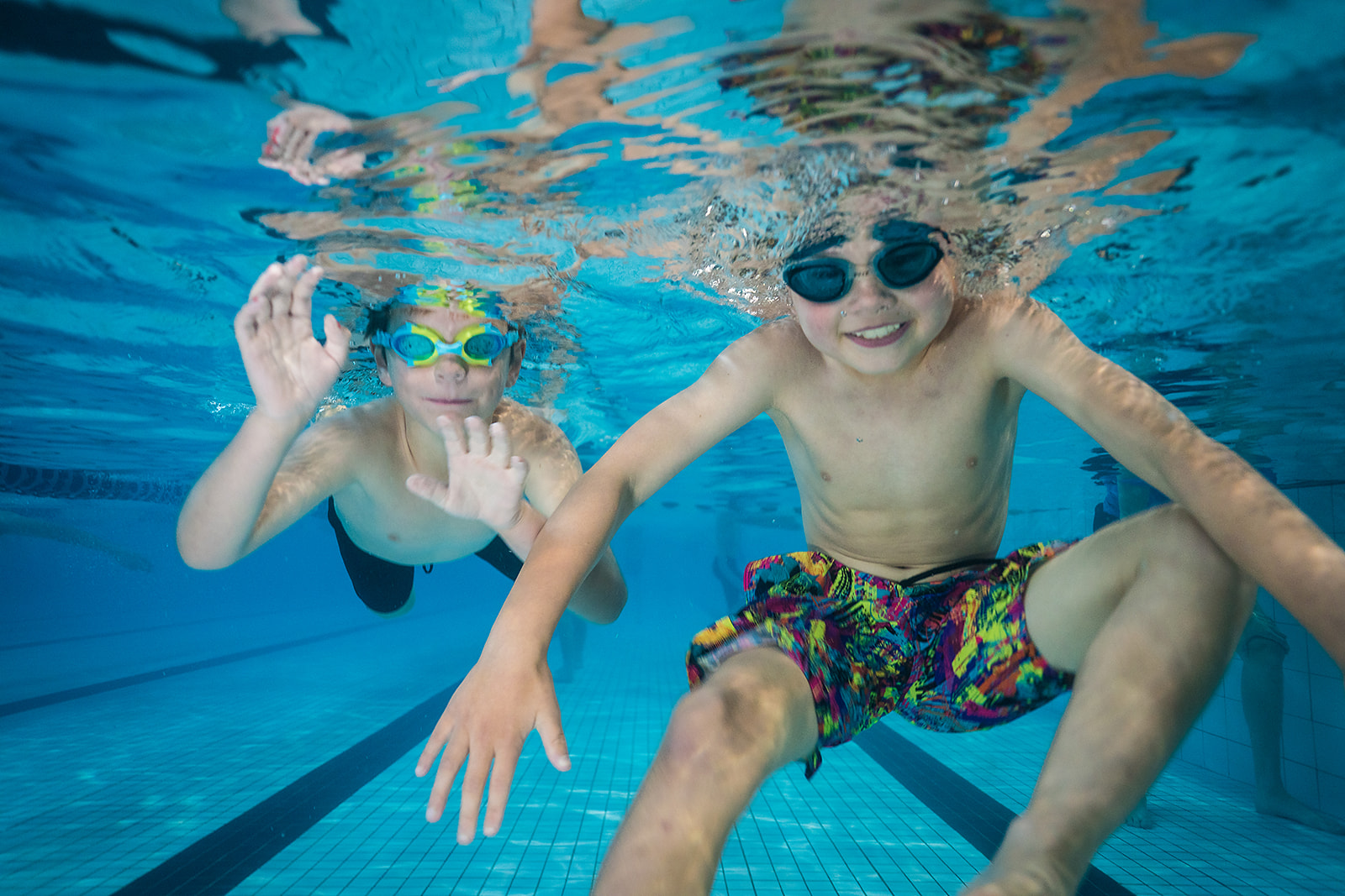 Two smiling boys underwater at Christchurch Recreation and Sport pool. 
