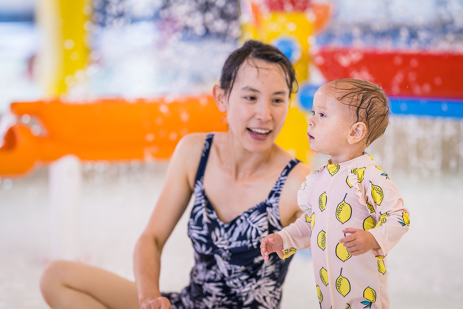 A toddler playing in the toddler pool with a smiling woman at Christchurch Recreation and Sport pool. 