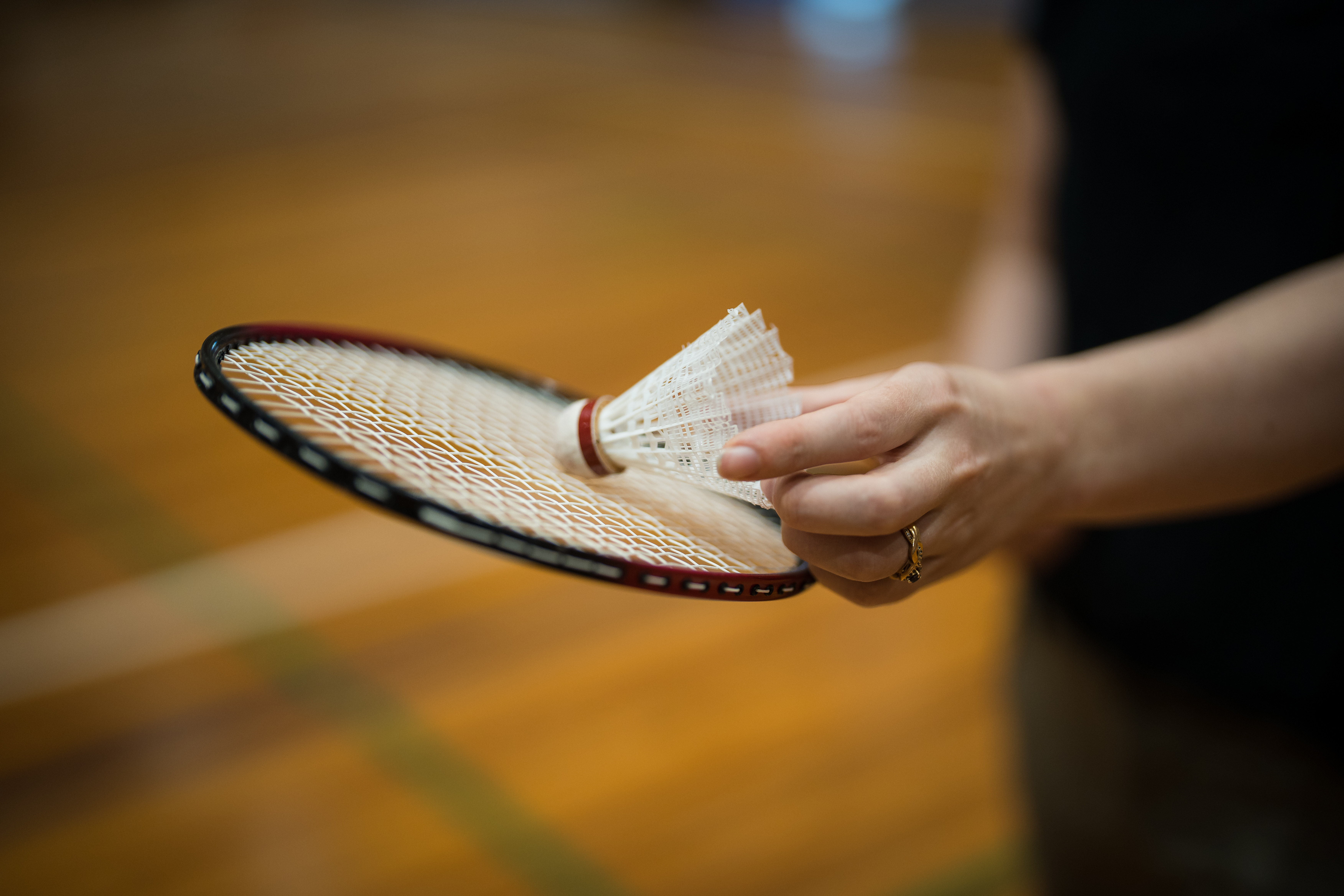 A woman holding a badminton racket and white birdie at Christchurch Recreation and Sport. 